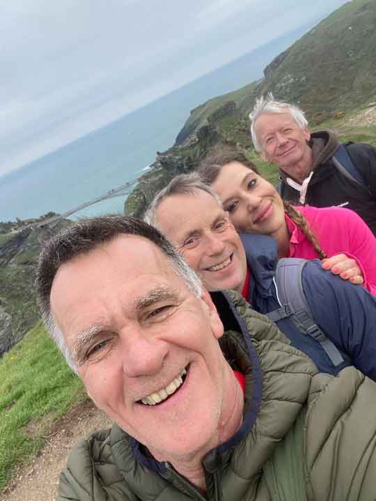 Four people participating in the Smallman Hike standing together overlooking Tintagel Castle bridge