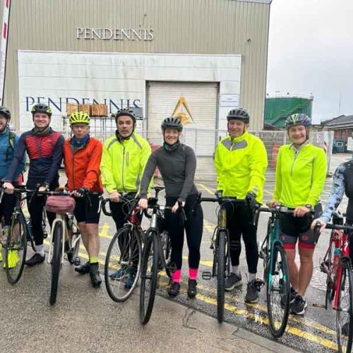 Group of cyclists from Pendennis Shipyard holding their bikes.