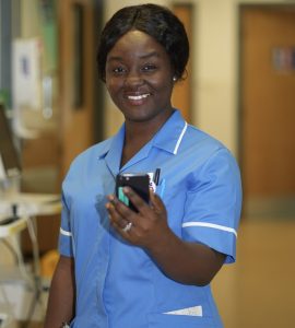 Nurse on a ward holding a mobile phone