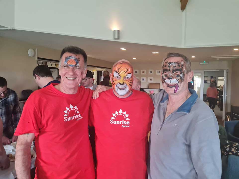 Three participants of the Smallman Hike celebrate with animal face paintings